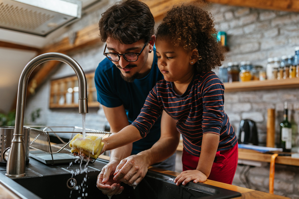 father and daughter washing hands